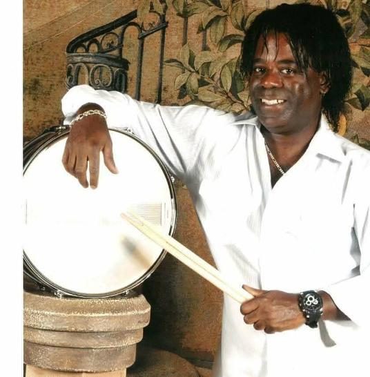 Robert Becton smiling, holding a snare drum and sticks